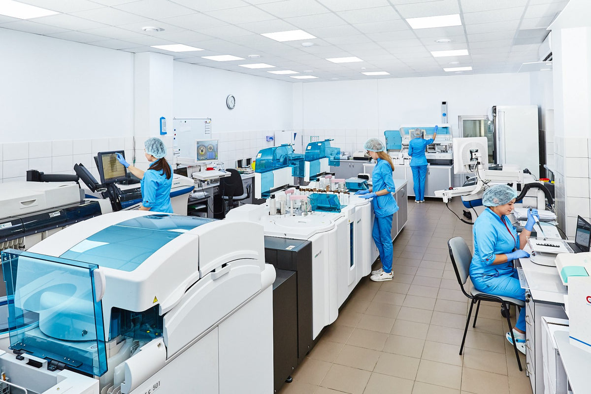 Scientists in lab coats and gloves testing samples, the kind of batch testing that checks creatine purity