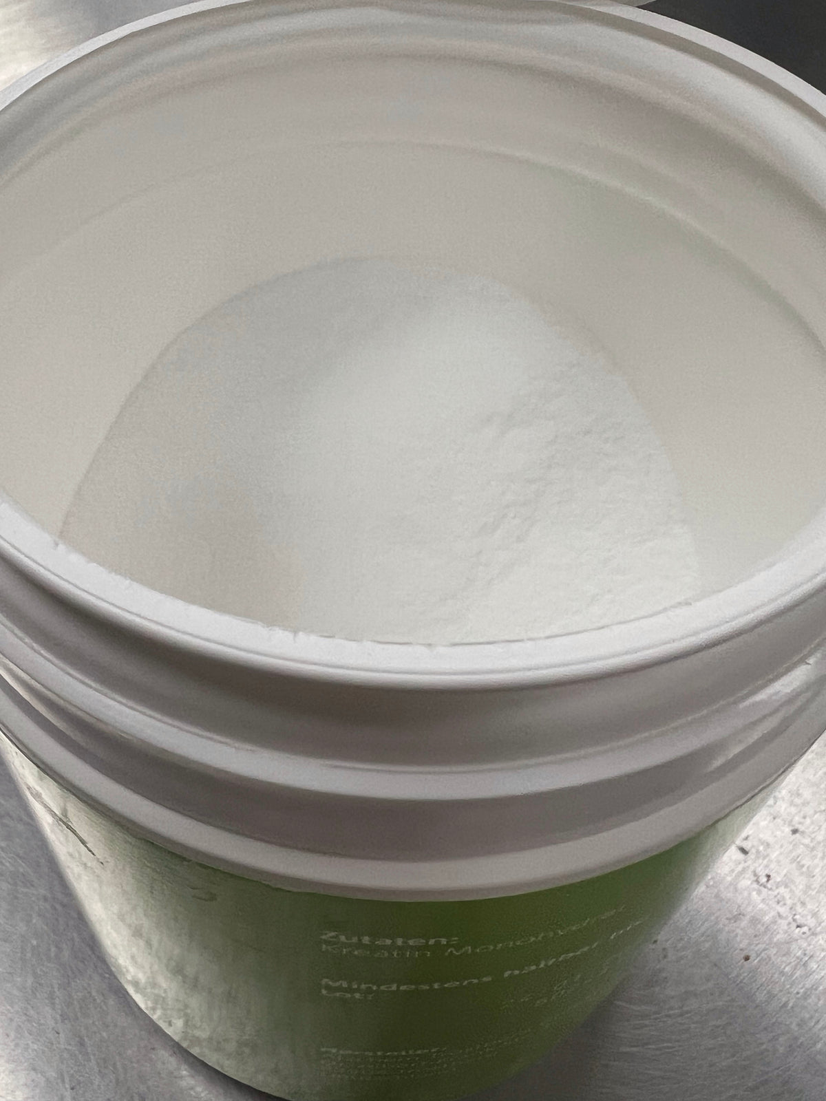 A scoop of plain white creatine monohydrate powder, the form used in most creatine research