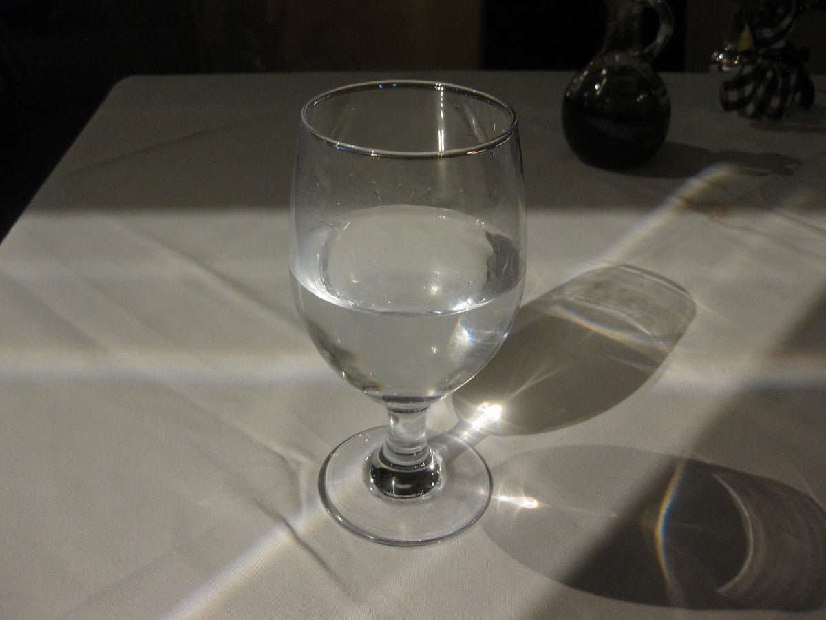 A clear glass of water catching the light, a nod to the water creatine pulls into muscle