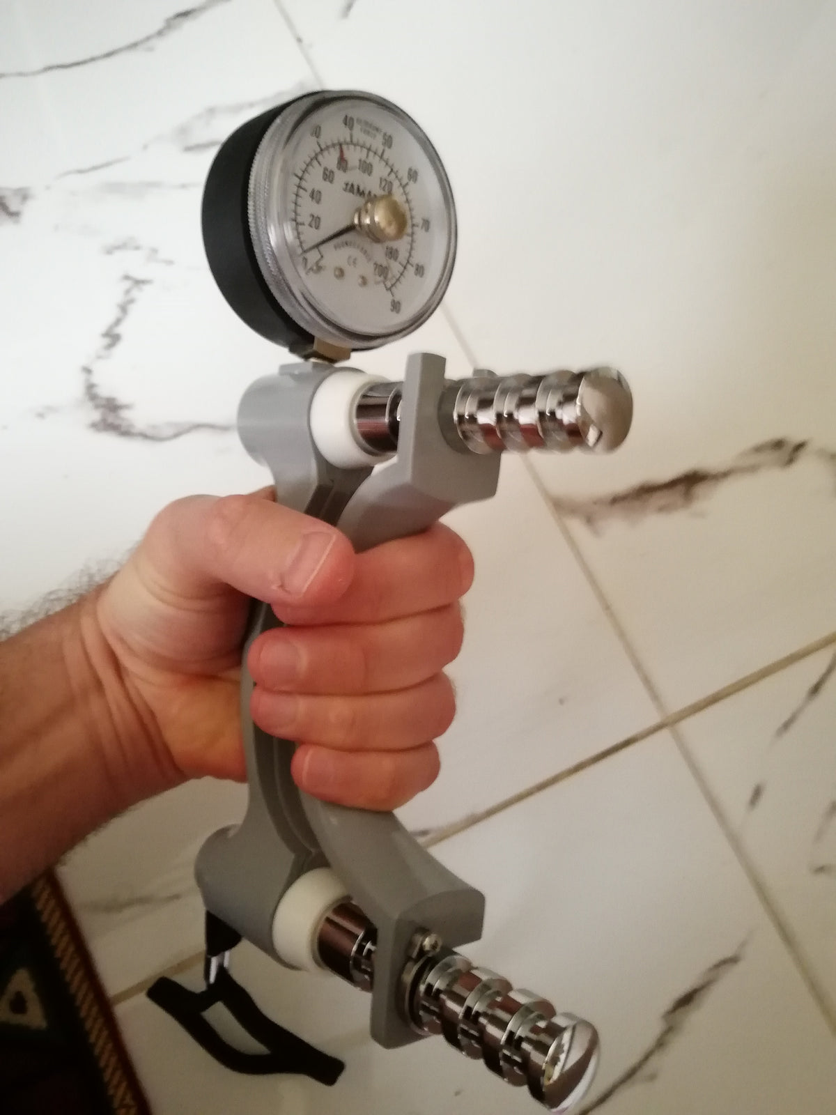 A hand gripping a hand dynamometer, the device doctors use to measure grip strength when checking for sarcopenia
