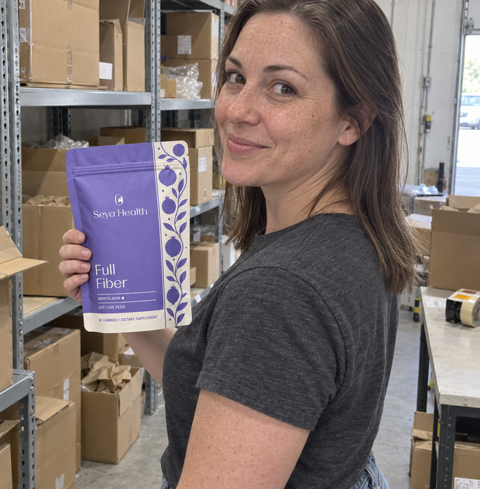 A woman holding Seya Full Fiber in a warehouse